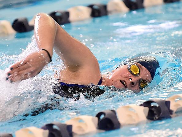 A Penn State Behrend swimmer competes in a freestyle race.