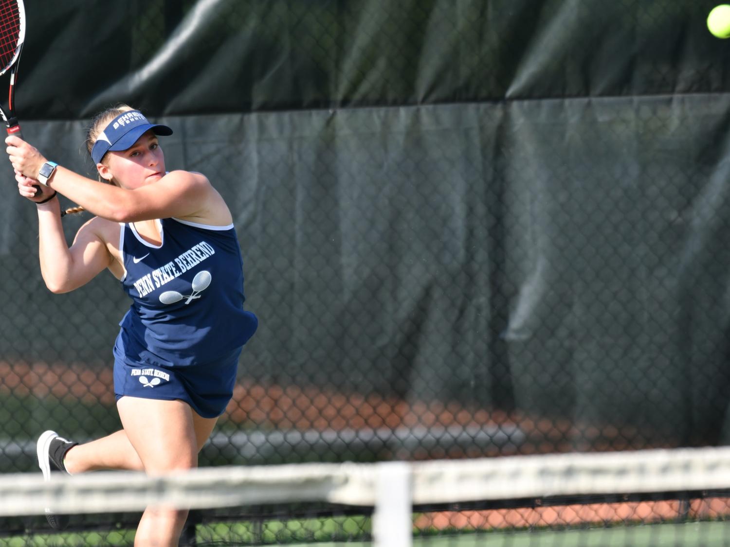 A Behrend tennis player hits the ball.