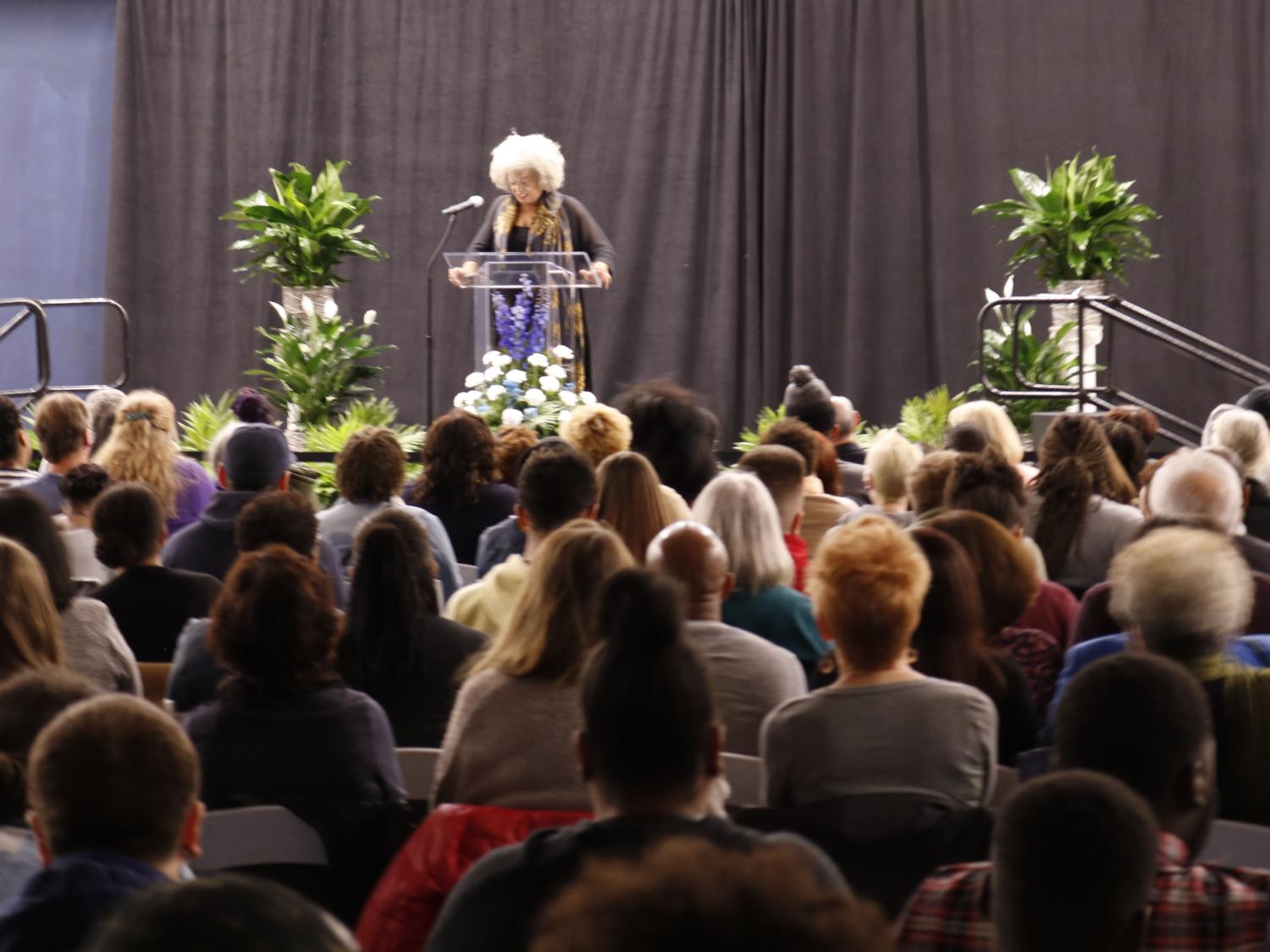 Dr. Angela Davis standing on stage preparing to talk to a crowd of people. 