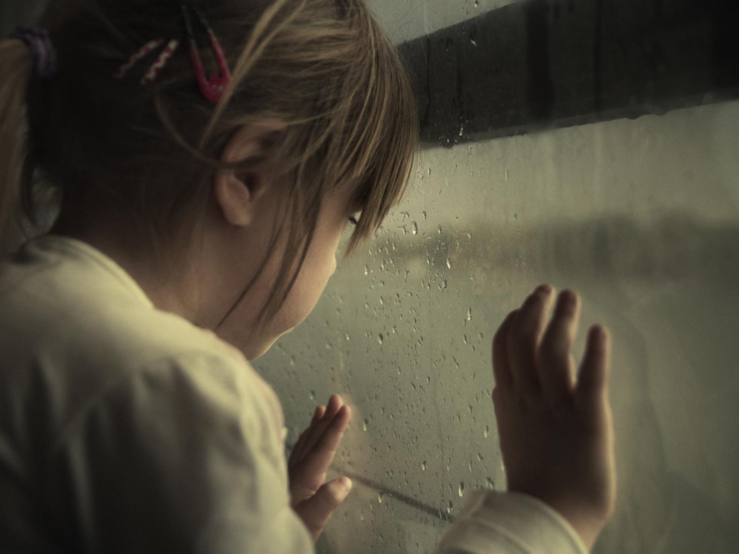 child rainy window