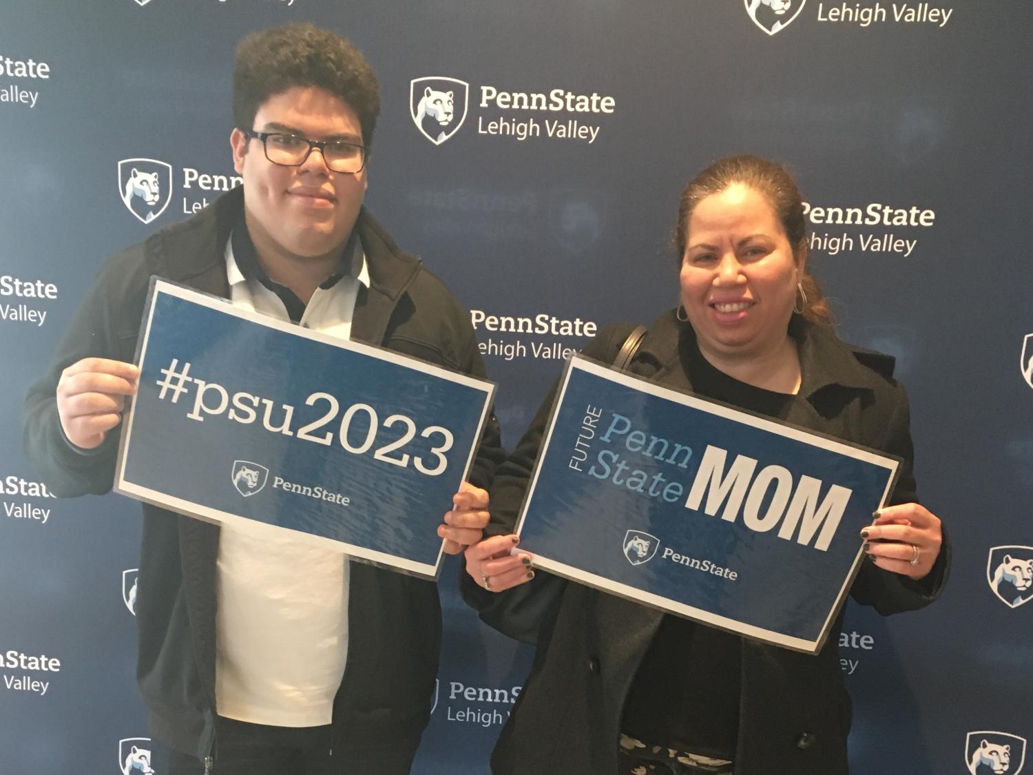 young man and his mother holding Penn State signs
