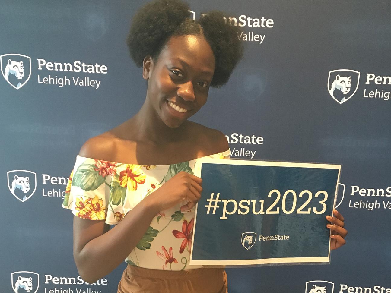young student holding sign with #psu2023