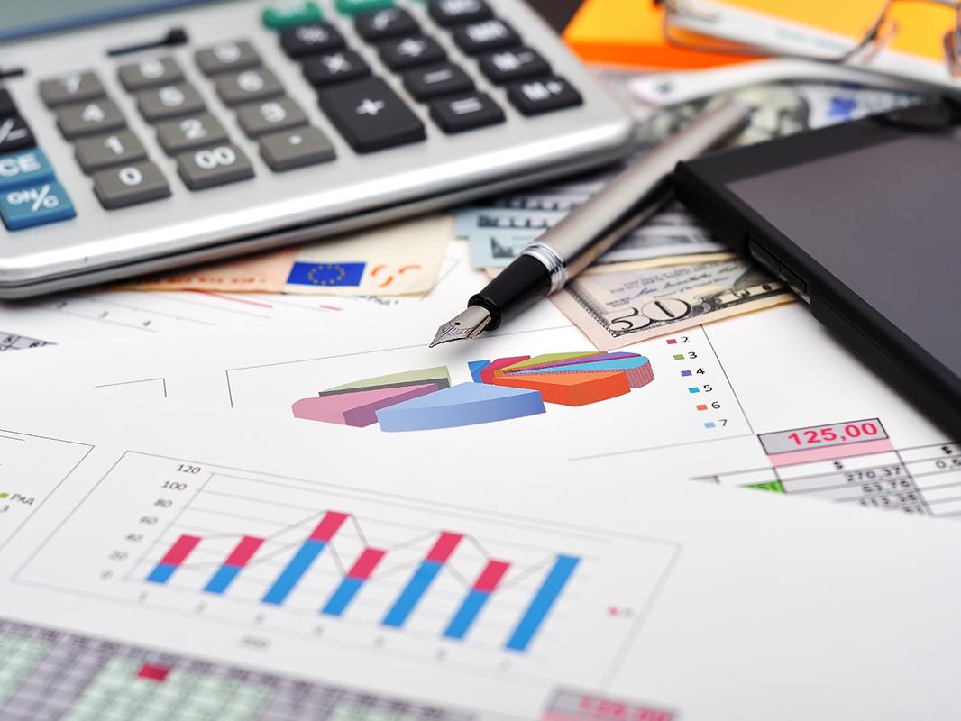 Accounting stock photo including charts, calculator, pen, and mobile phone