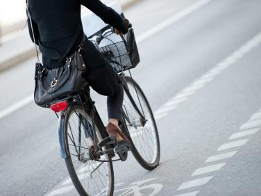 woman on bike wearing suit and low heels