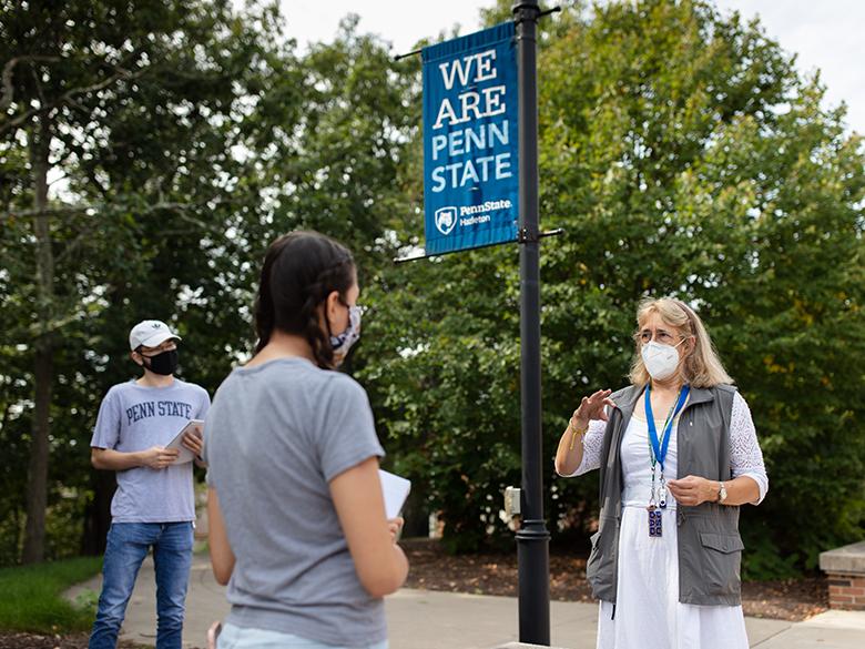A professor talking to two students on the campus walk at Penn State Hazleton.