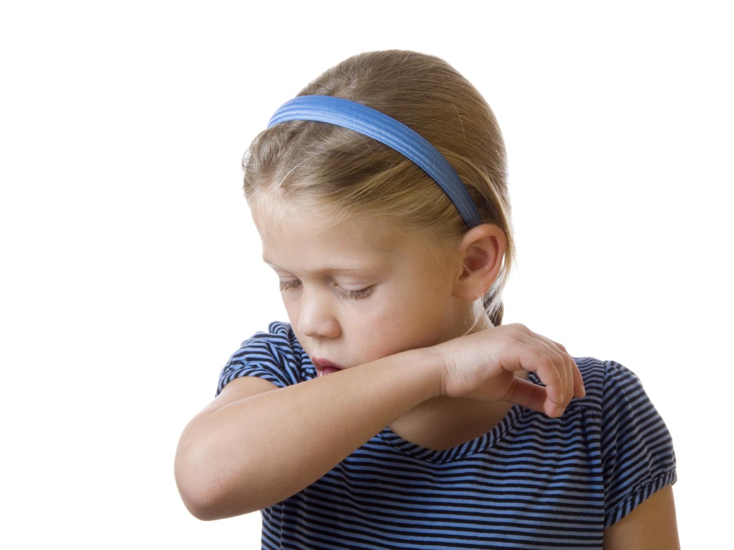 girl coughing onto elbow