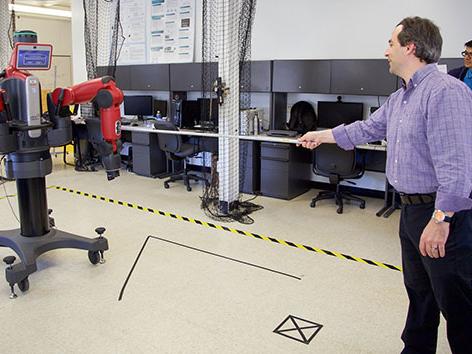 Alan Wagner, assistant professor of aerospace engineering, conducts an experiment with a Baxter robot in the Robot Ethics and Aerial Vehicles Lab