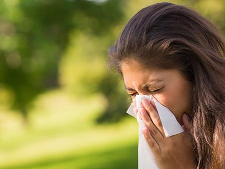 A woman blows her nose.