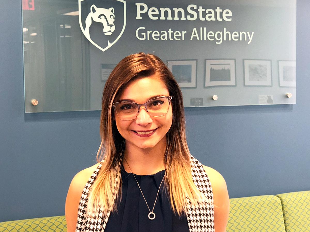 Exchange student Amanda Diana in front of the Penn State Greater Allegheny Logo. 