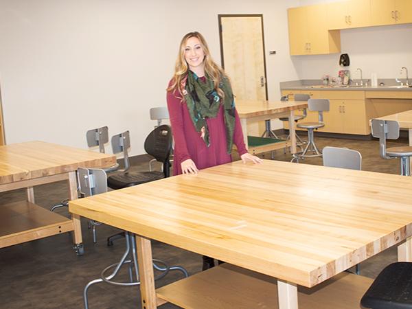 Lecturer in Art, Corianne Thompson stands near large art table in new Art Studio on Scranton Campus