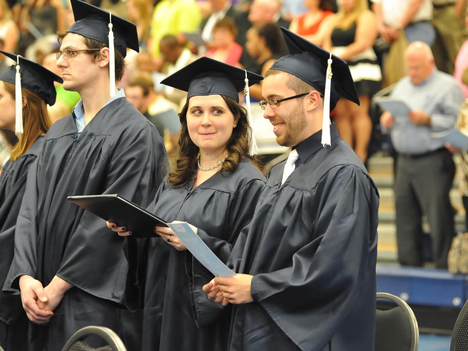 Dan Trzcianka studies the words of the Alma Mater as Kim Villella looks on at Penn State Beaver's graduation, May 3, 2013