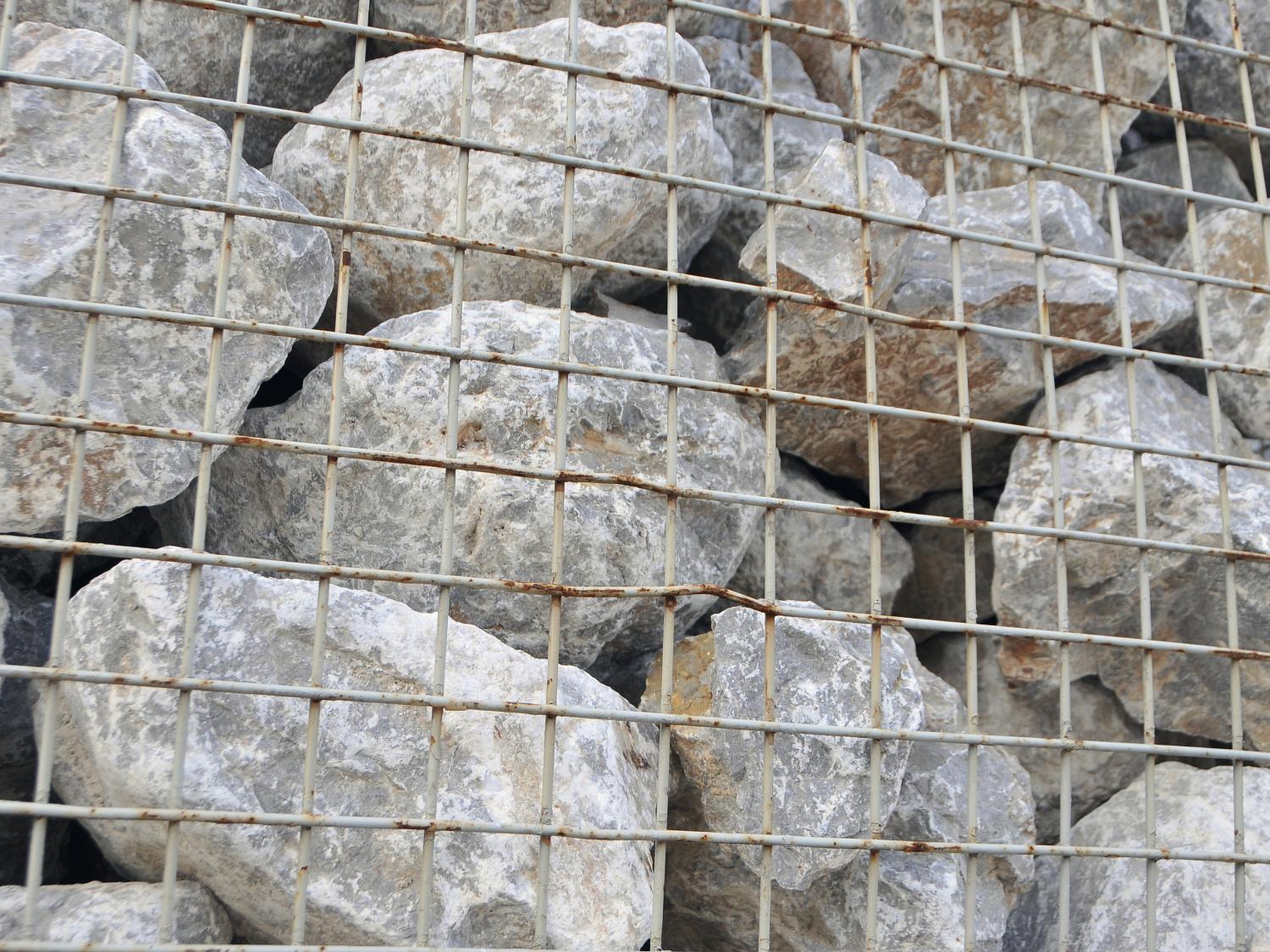 boulders behind wire fence