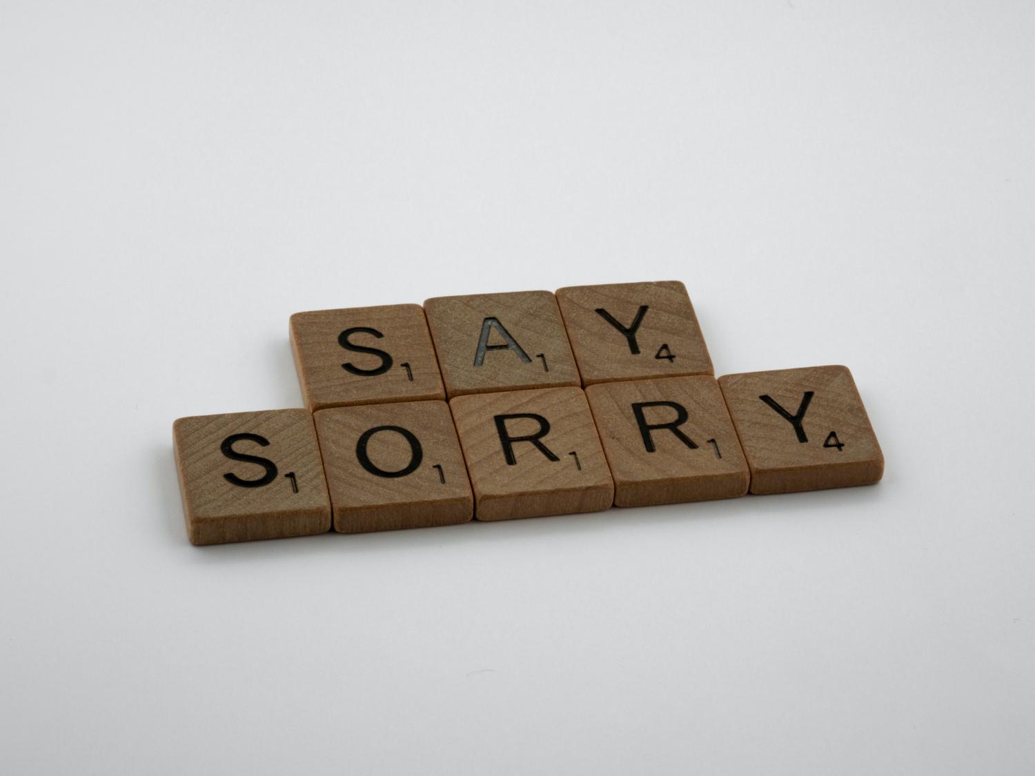 Scrabble tiles spell out "Say Sorry"