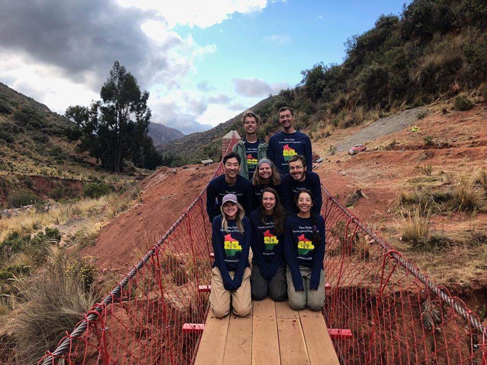 A group of students gathered together on a bridge.