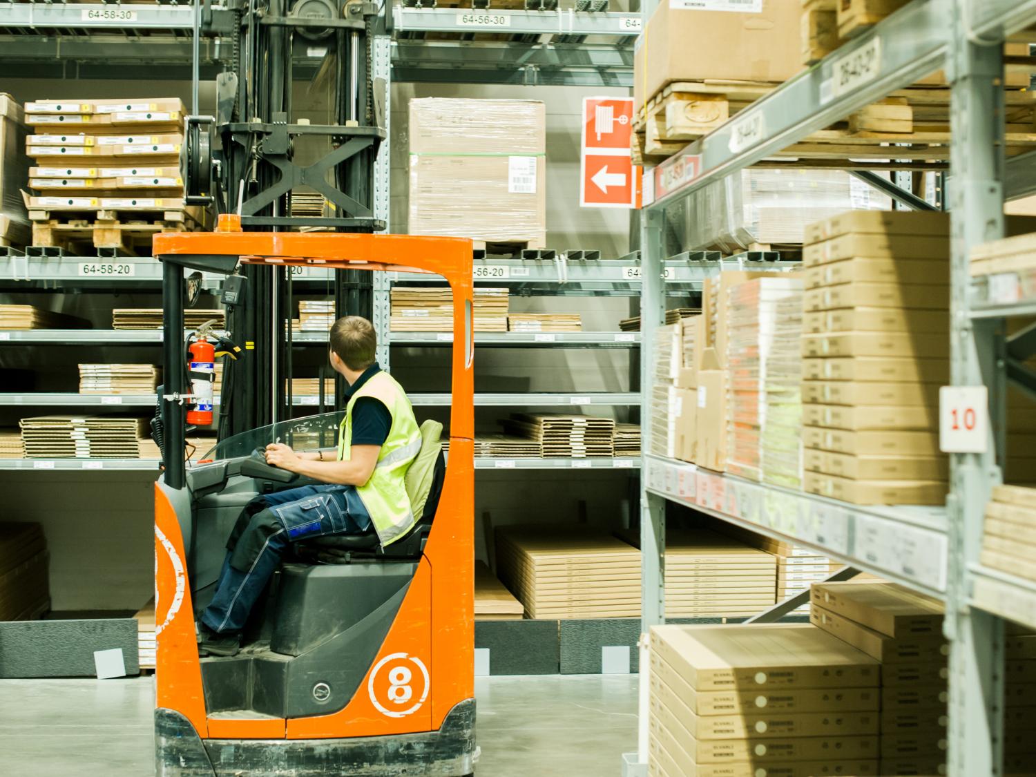 A worker moves product in a warehouse distribution center.