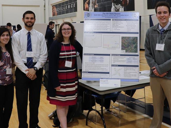A group of engineering students stand by their poster at the spring 2019 Capstone Design Showcase
