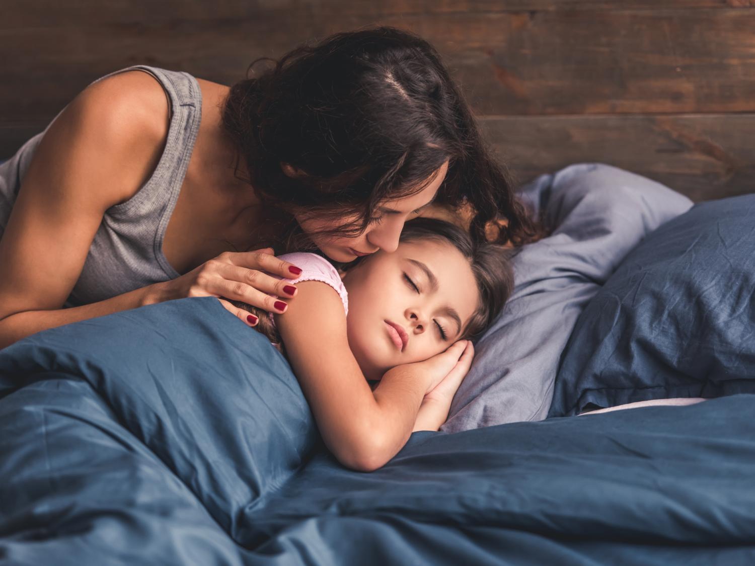 Mom kissing sleeping child