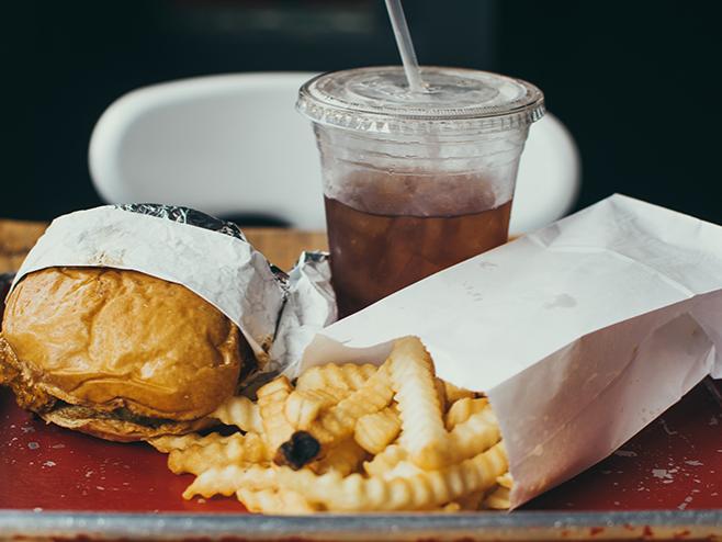 Burger, fries, and soda on a tray.