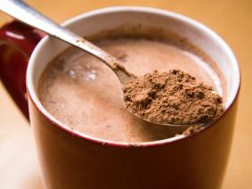 cup of hot cocoa and spoon of cocoa powder
