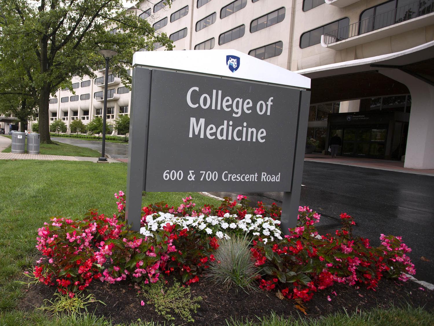 A gray sign reading College of Medicine is in front of a hospital