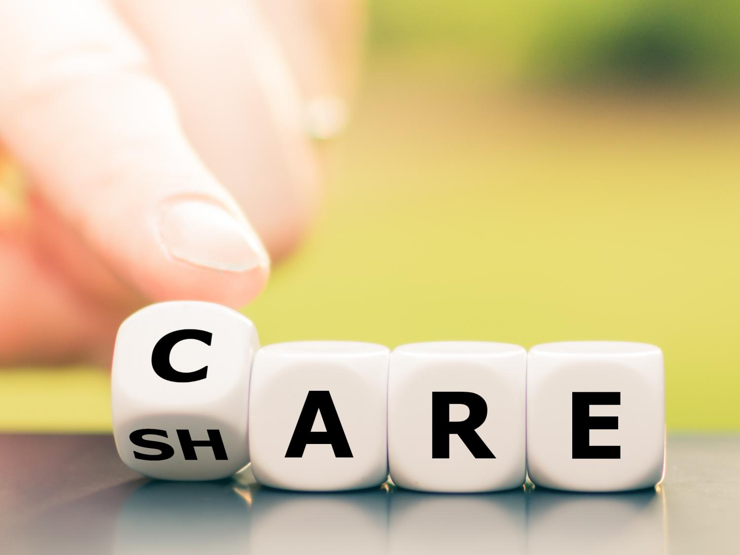 A finger pointing to letter blocks spelling out "care"