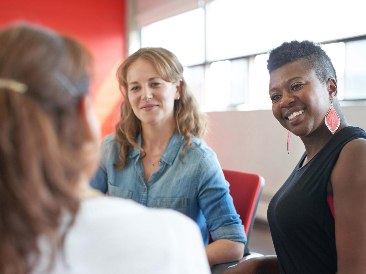 3 women talking around a table