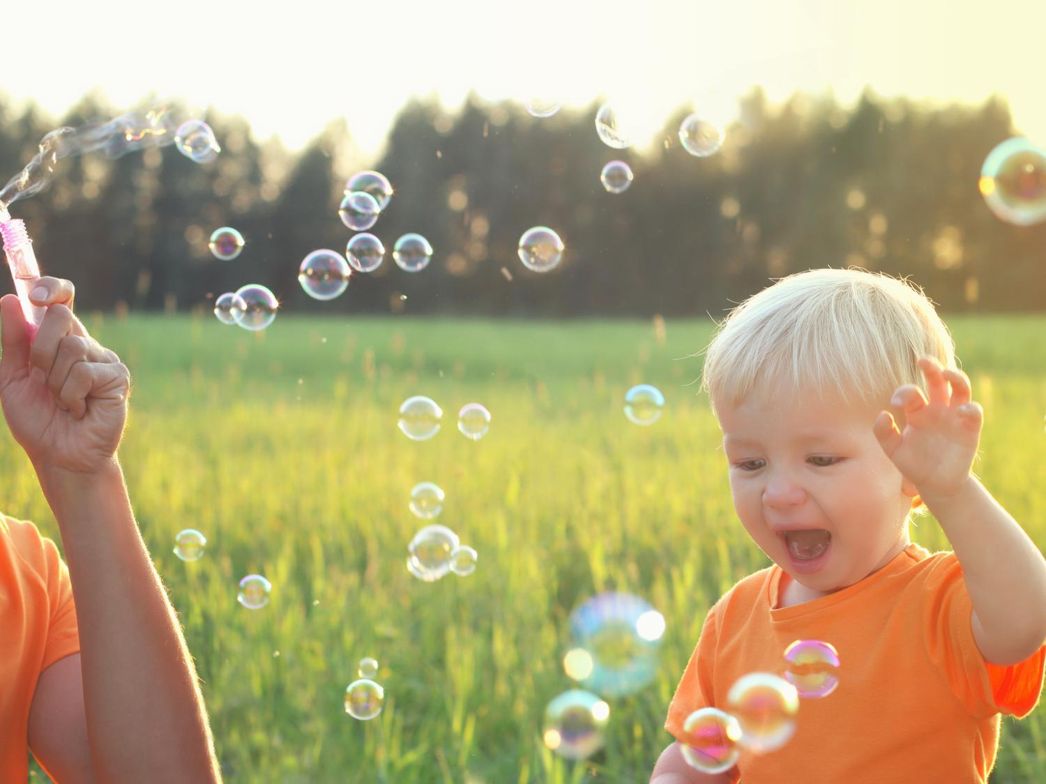 dad and toddler blowing bubbles