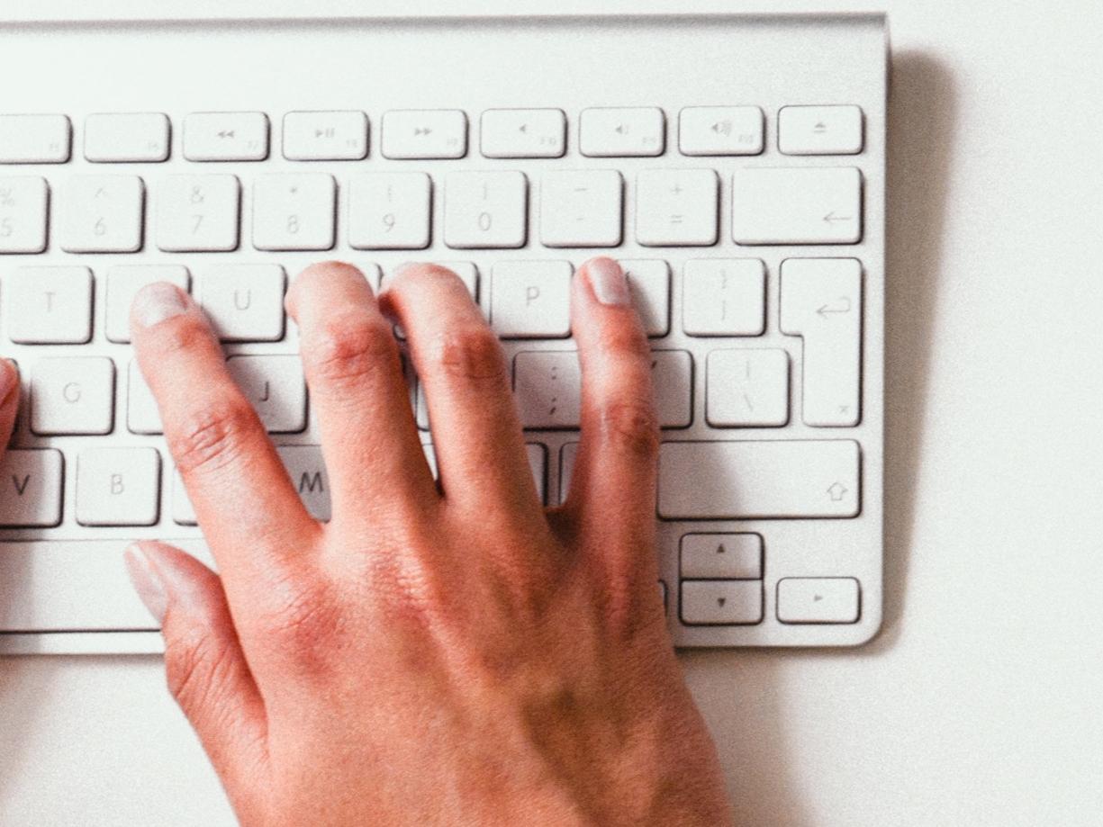 hands typing on computer keyboard