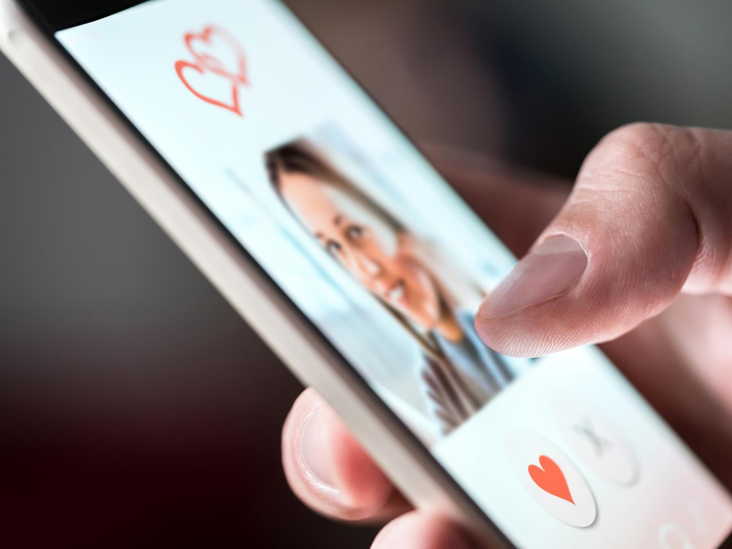 Person scrolling a dating app on a phone