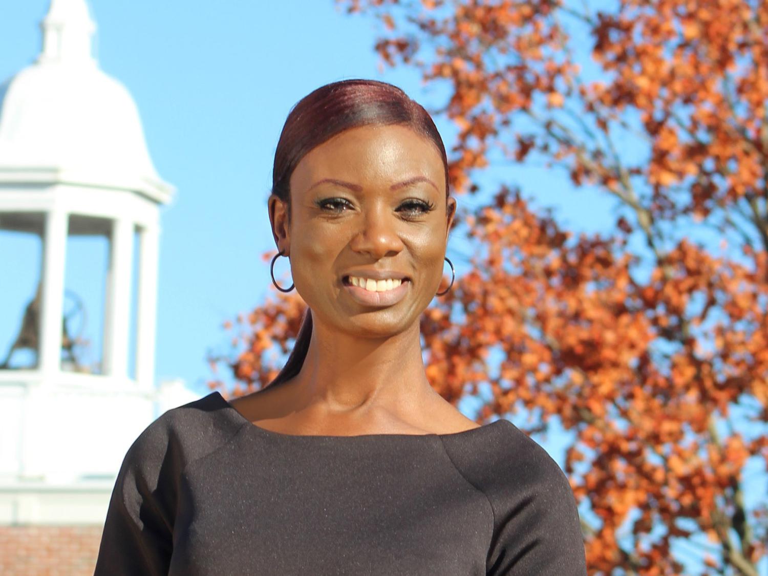 Denita Wright Watson is seen with an historic building and fall foliage in the background