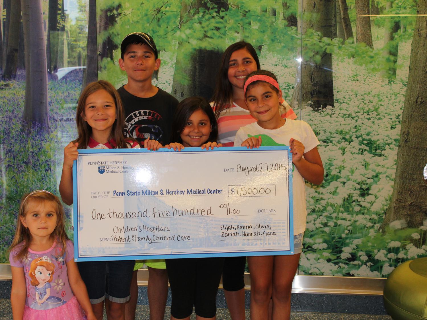 Members of two families pose with a donation check.