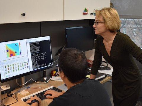 woman and man reviewing research graphics on computer
