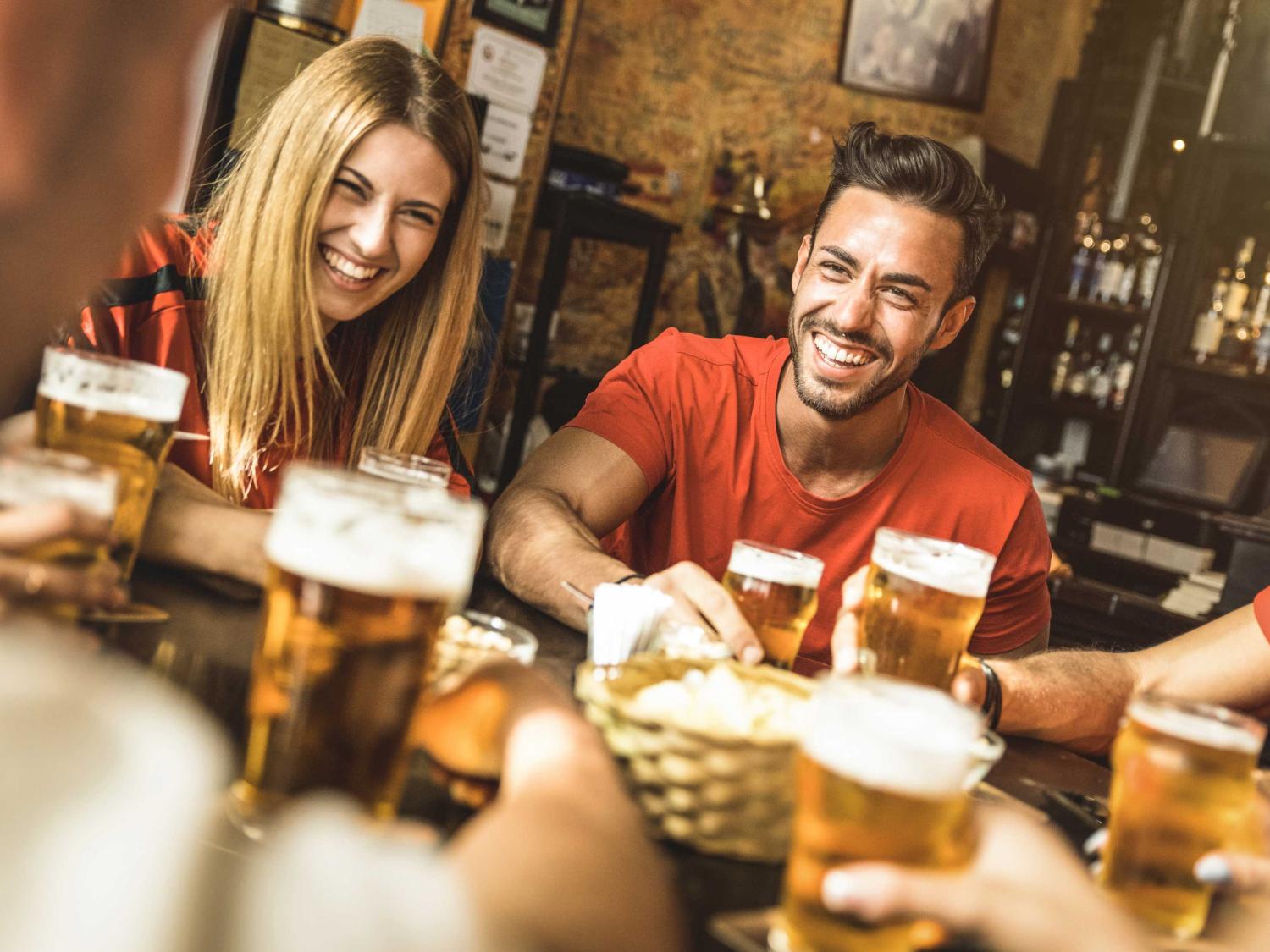 Young woman and man drinking at bar