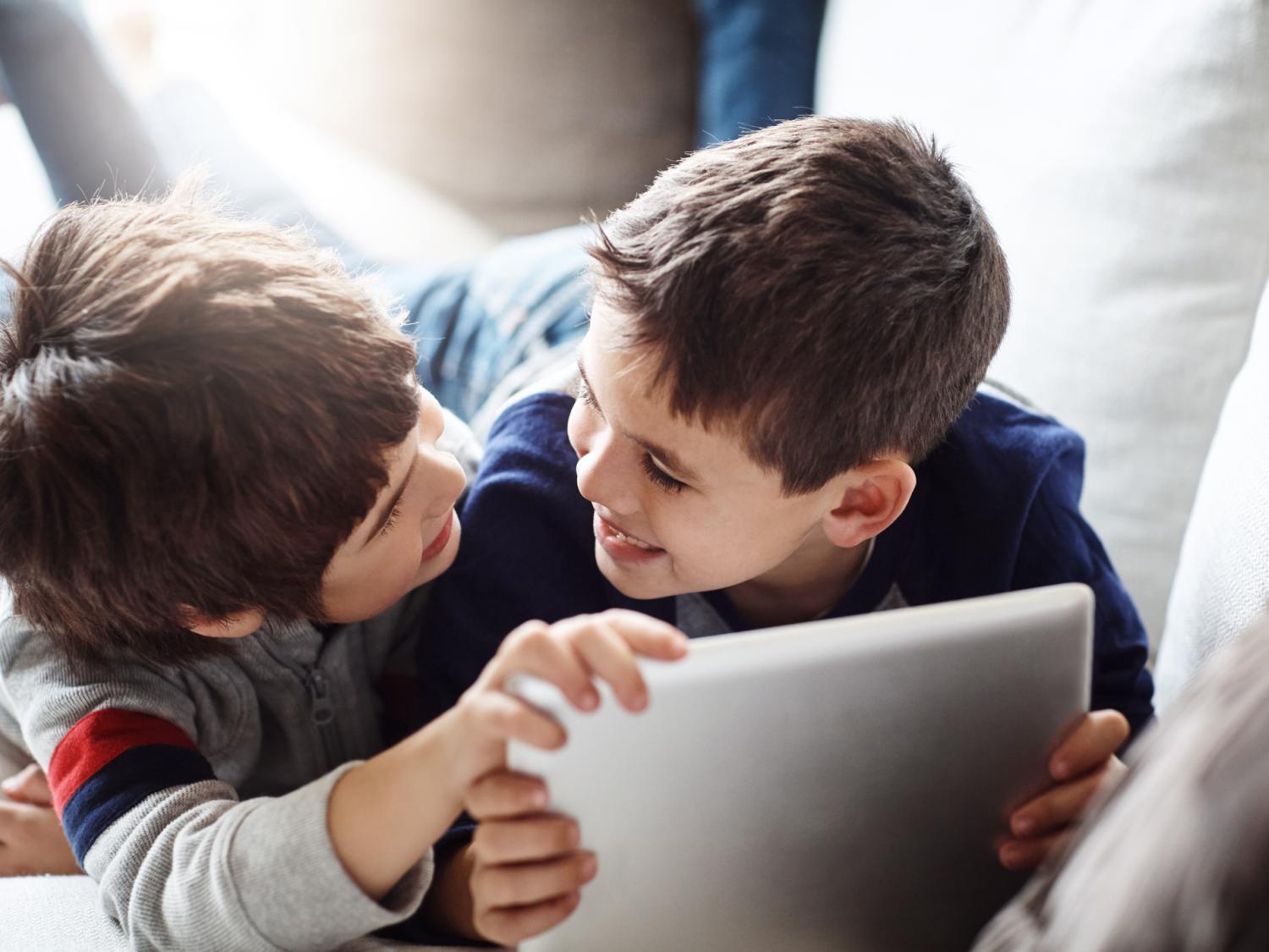 Two children playing on a digital tablet together
