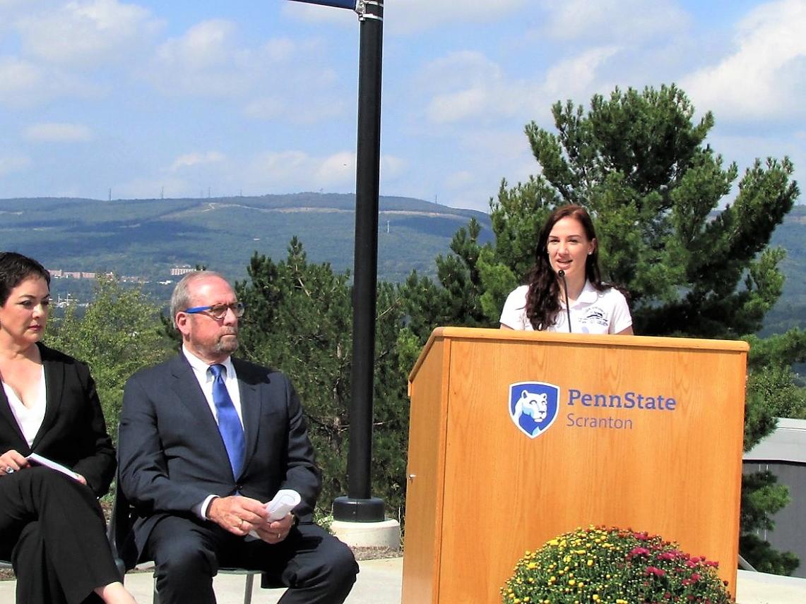 emily scarfo at podium at patio  dedication speaking