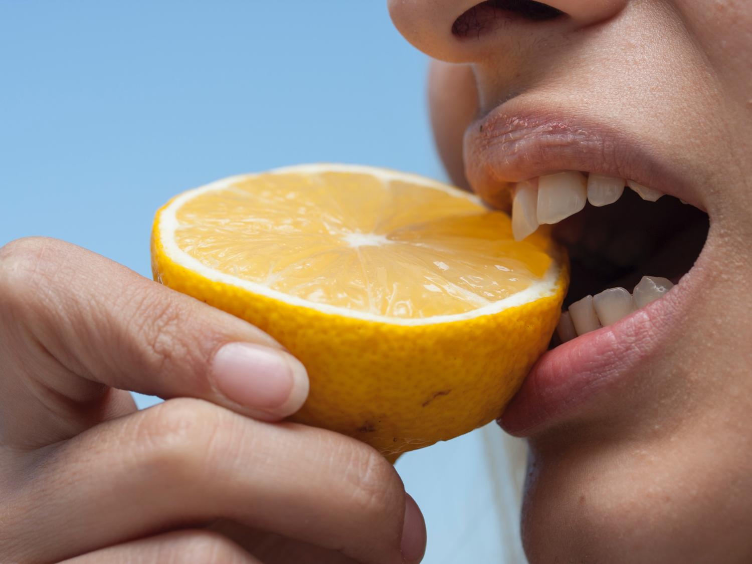 Person eating lemon