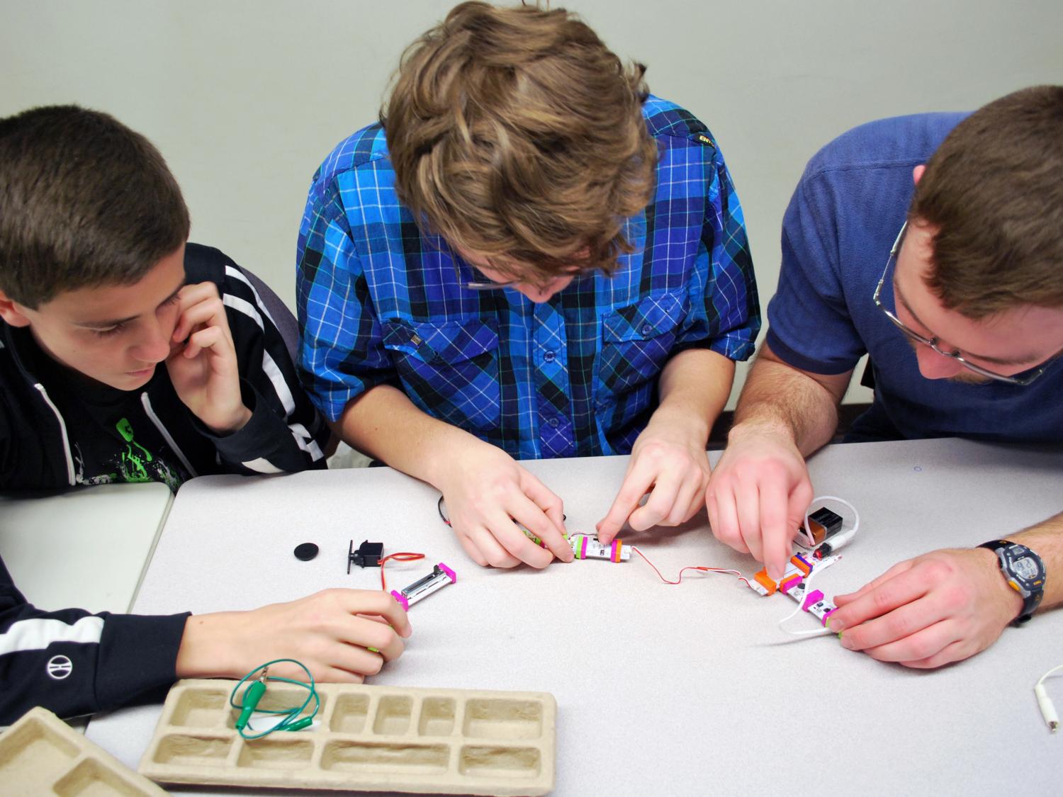 A group of young STEM students work on a littleBits kit