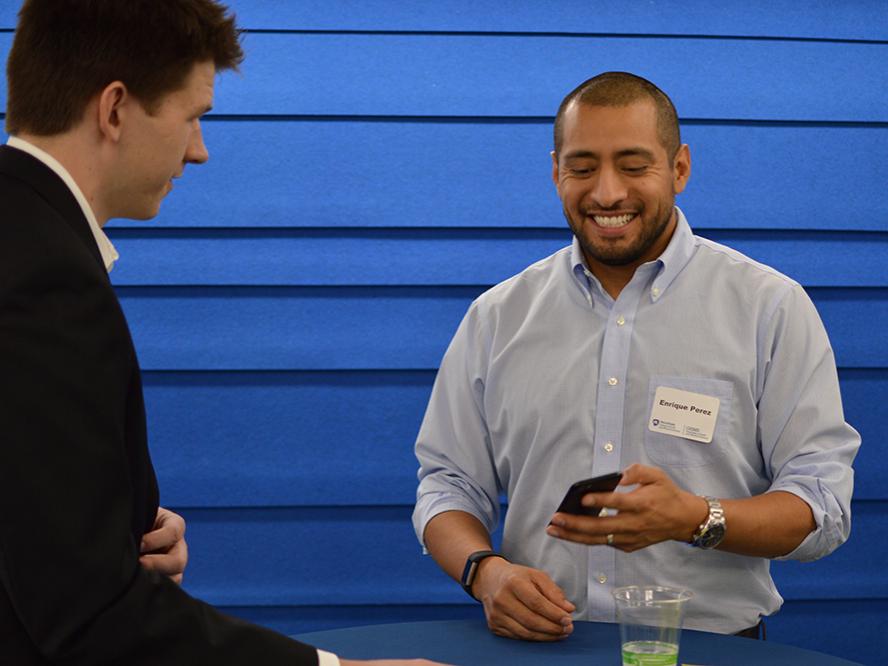 Enrique Perez chatting with student at mentoring program kickoff
