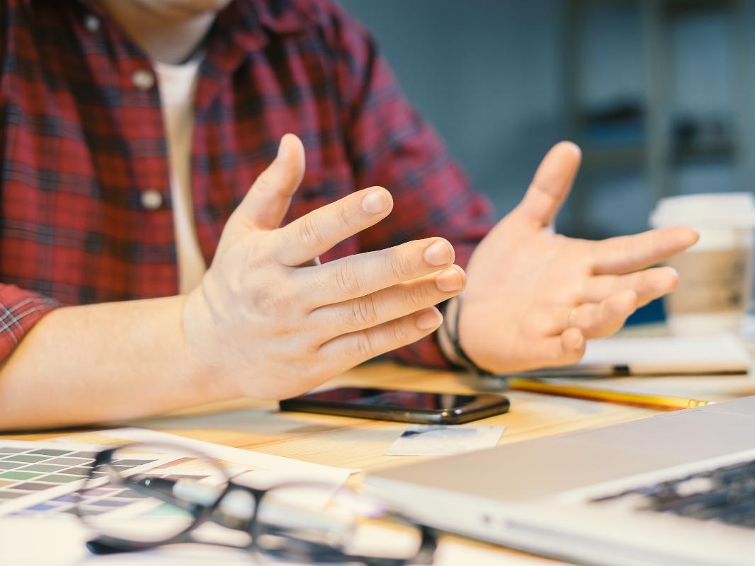 An image shows a person sitting at a desk with a papers on it