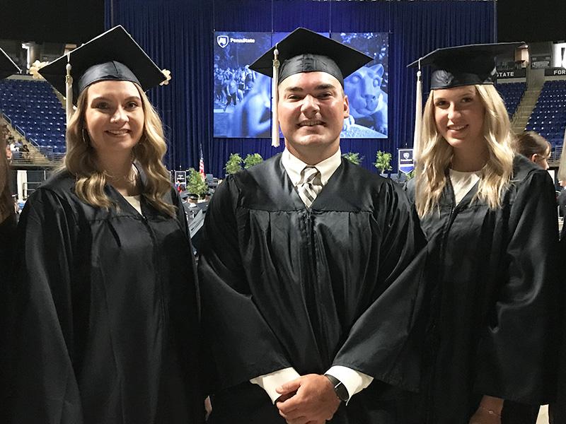 five individuals dressed in graduation caps and gowns