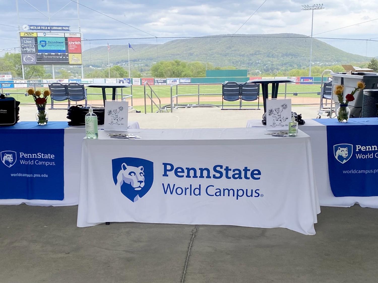 A Penn State World Campus tablecloth covers a table. A mountain is in the background.