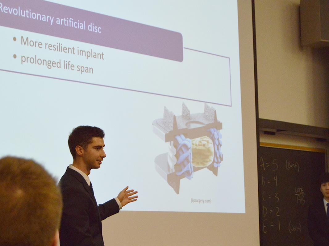 Penn State student points to an image of a vertebrae on a presentation screen.