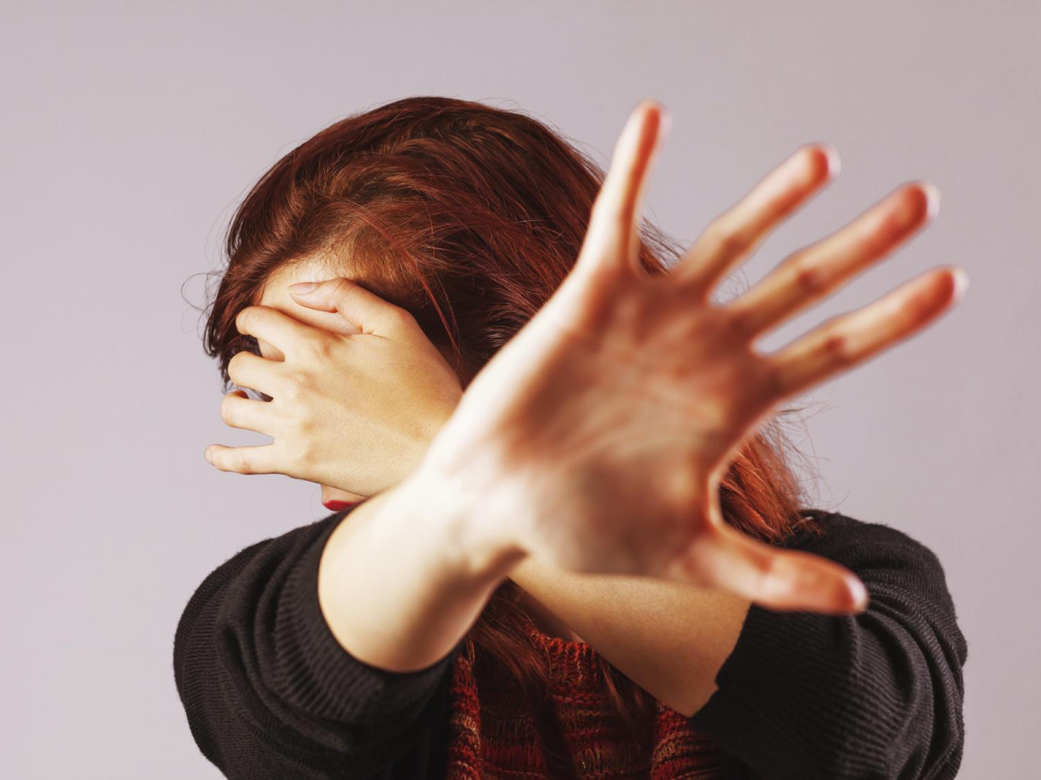 woman protecting self with hands