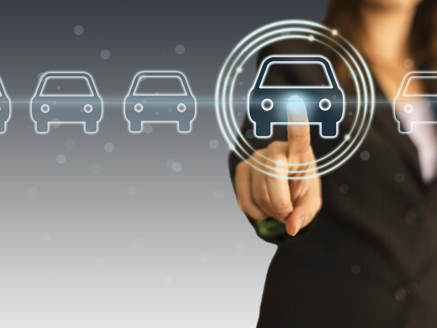 Image of woman touching screen with car logo.