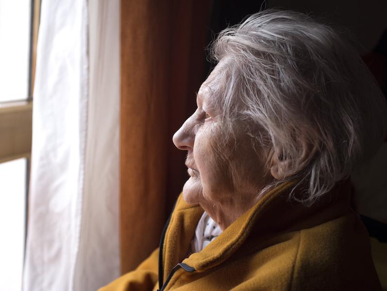 Old woman looking out a window