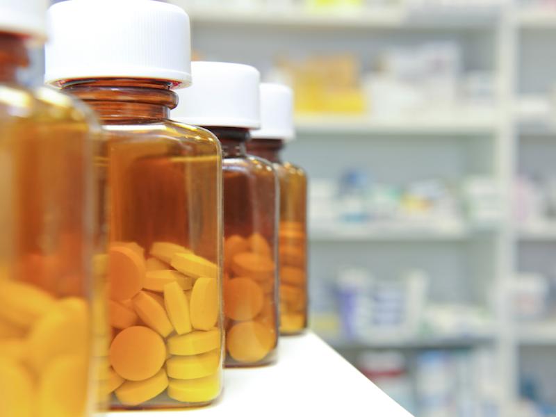 Row of pill bottles on a pharmacy counter