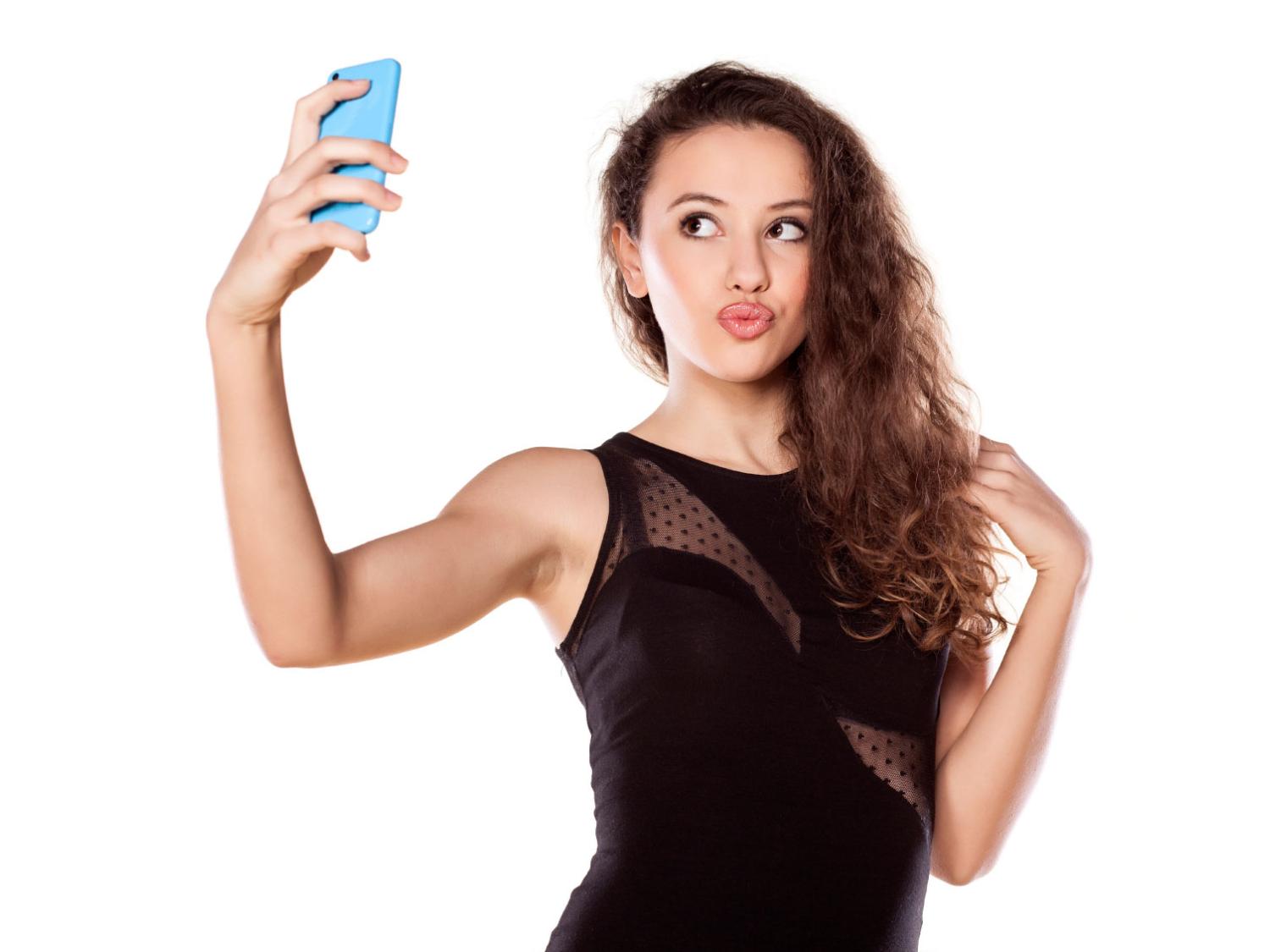 pretty teen girl taking selfies with her smart phone