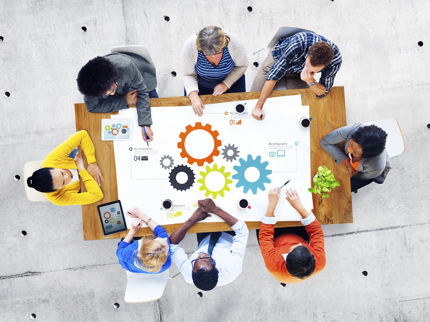 Team members work on a project around a table.