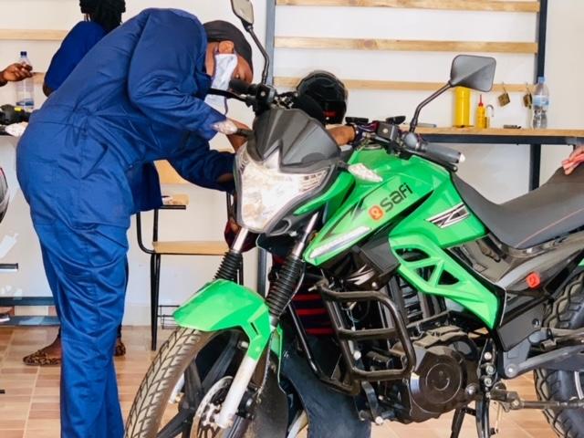 Two people work on a motorcycle.