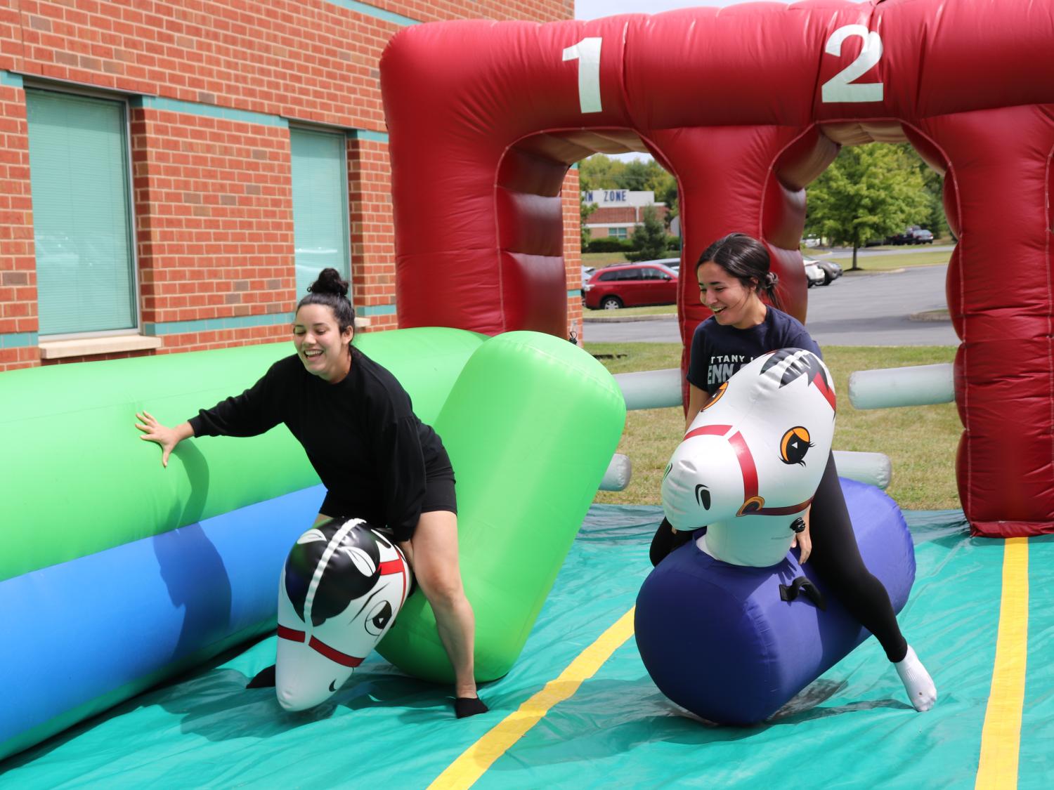 two young women riding inflatable horses